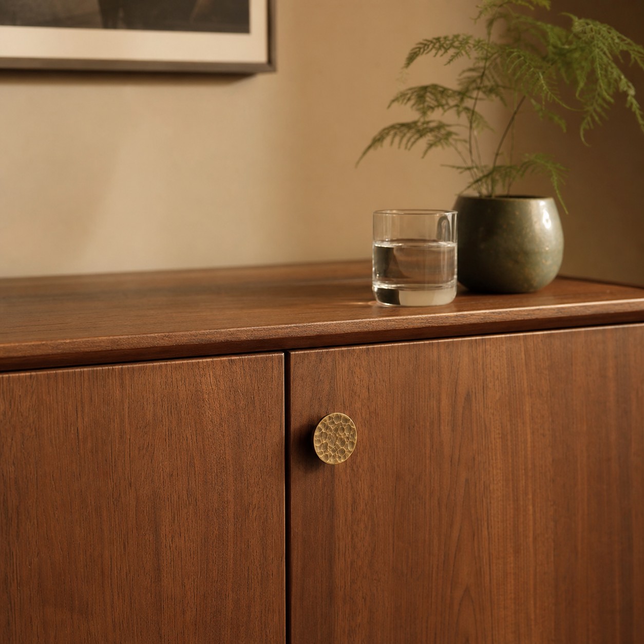 Hammered antique brass knob on a wood cabinet door