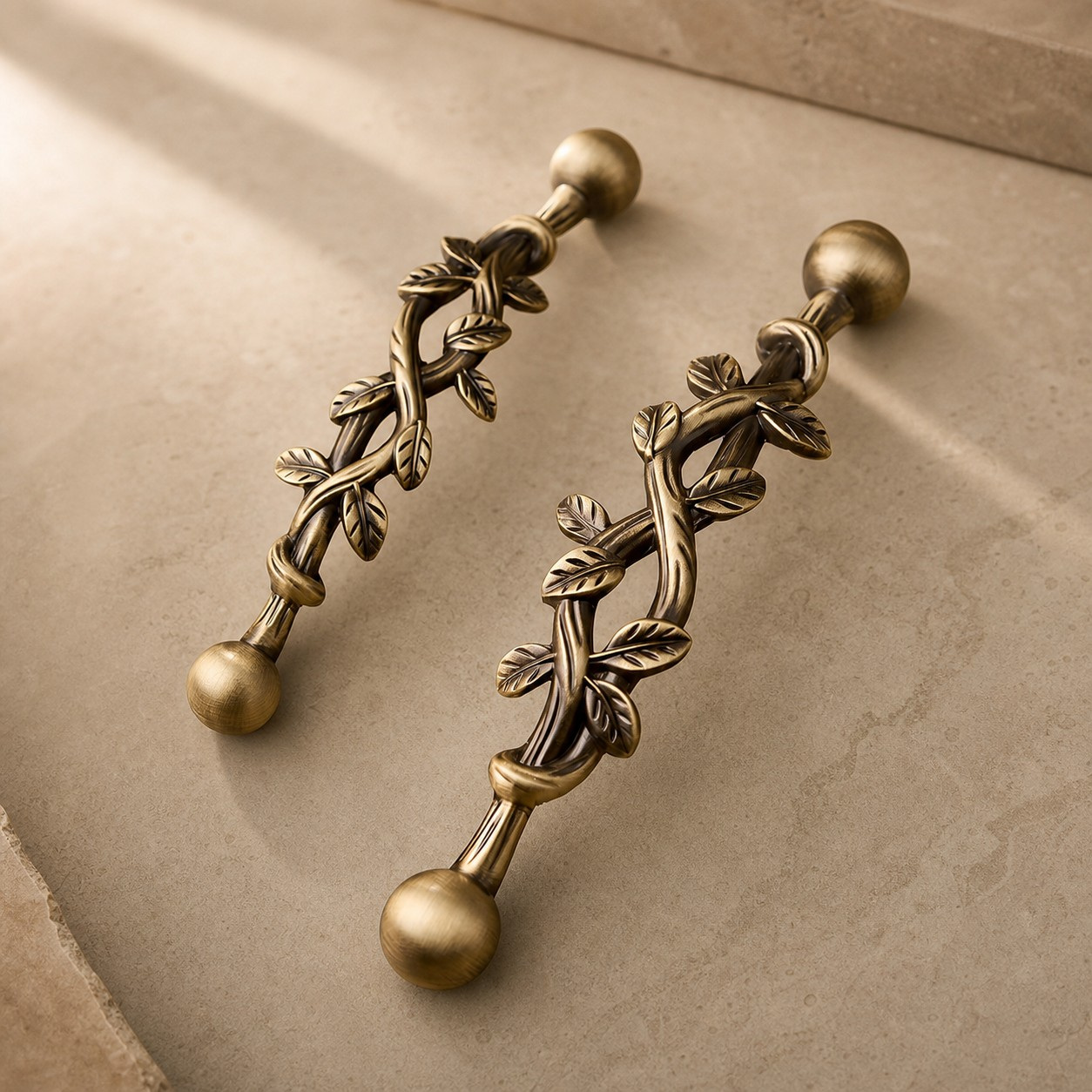Pair of leaf brass cabinet pulls on a stone surface